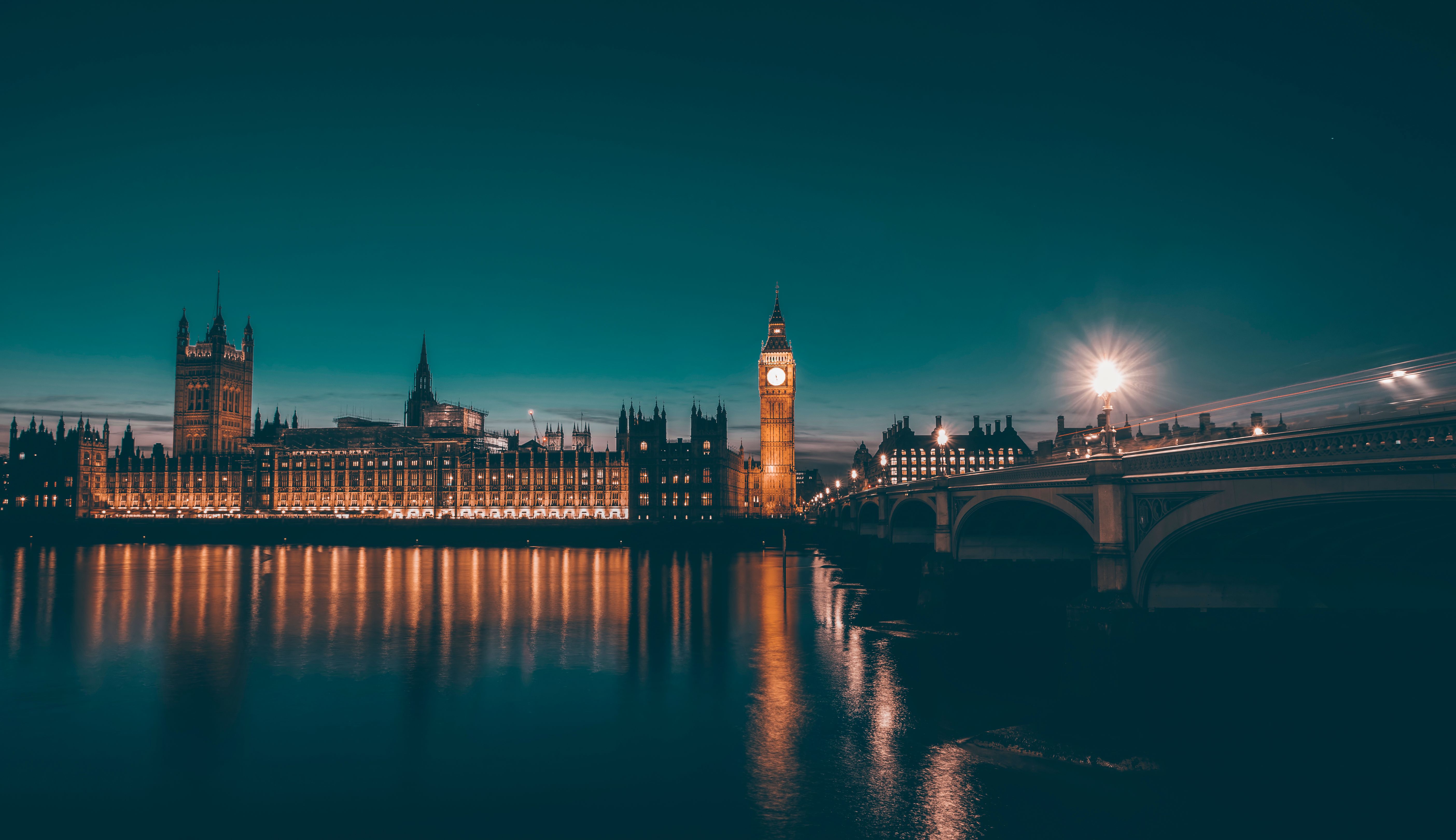 This is a photograph of the illuminated Big Ben clock tower and the Houses of Parliament in London, taken at night. 