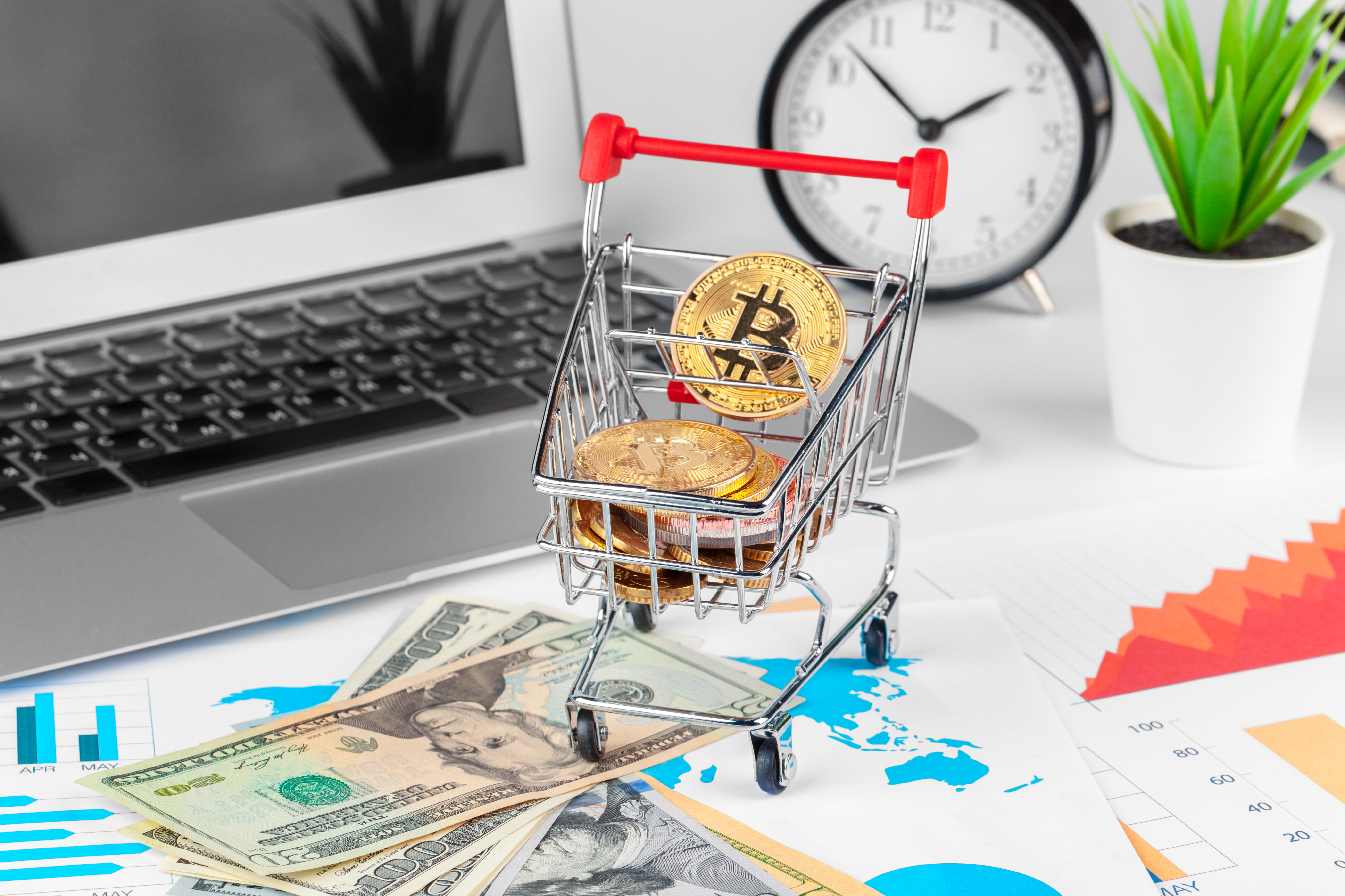 This photograph depicts a small, red-handled shopping cart filled with gold coins, symbolizing wealth or investment.