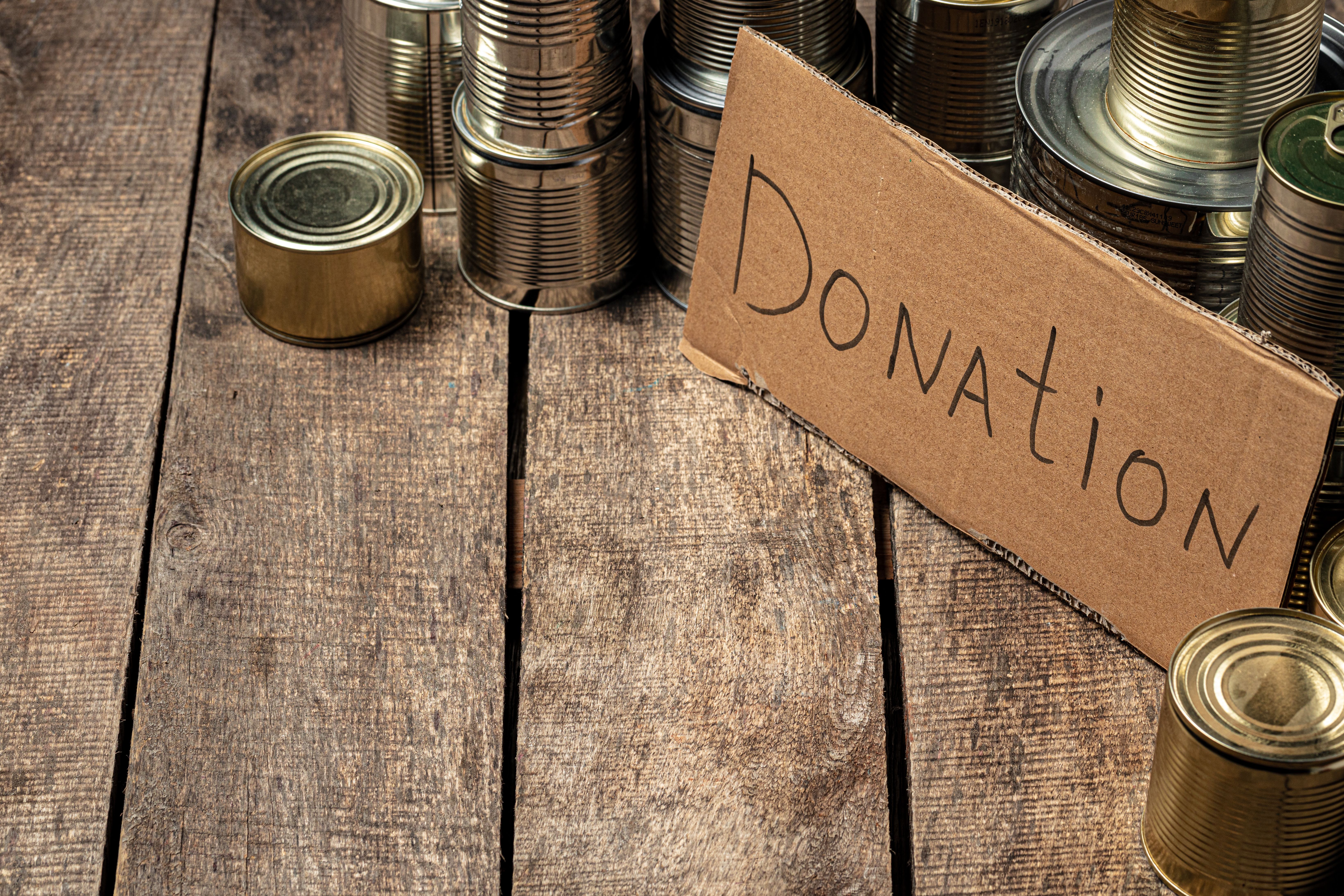 A small, rectangular brown cardboard sign with the word "Donation" written in black, handwritten-style text is prominently placed in the center-right of the image.