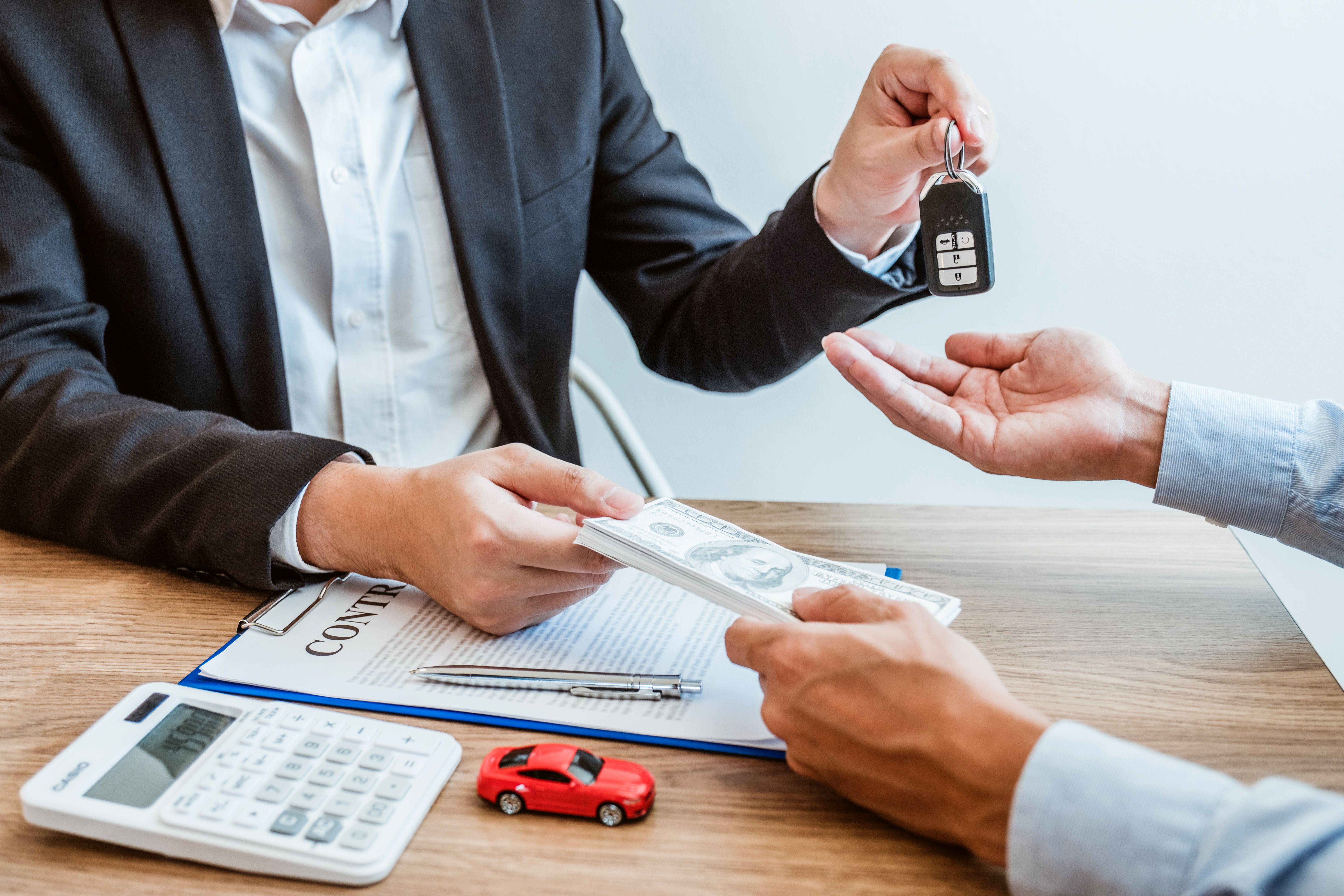 A photograph of a business transaction at a wooden table. 